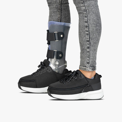 Billy Footwear (Mens) - Black Limitless Low Top Shoes feature a black knee brace, showcasing adaptive design with easy zip closure and cushioned support.
