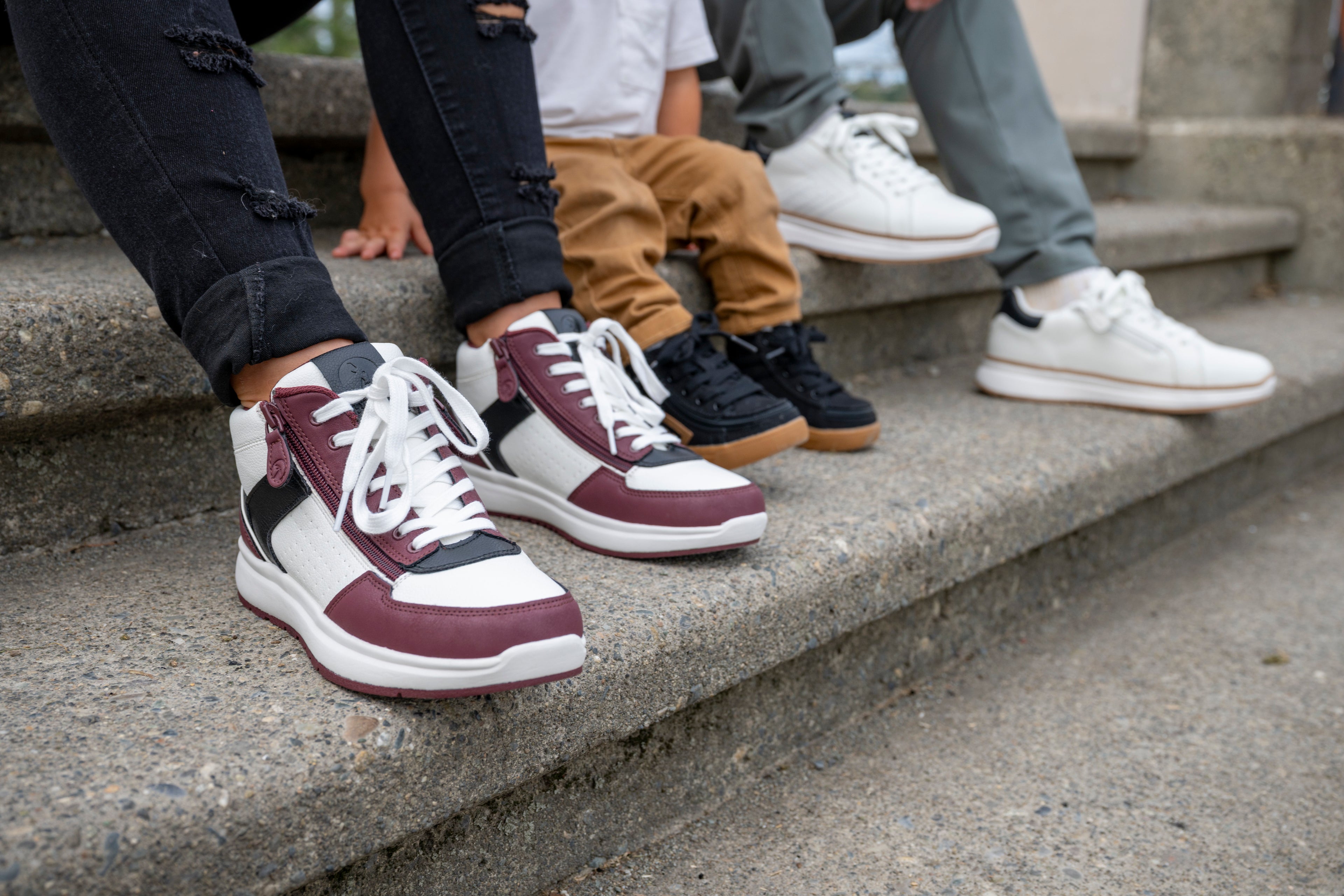 woman toddler and man sitting on steps wearing Billy Footwear trainers